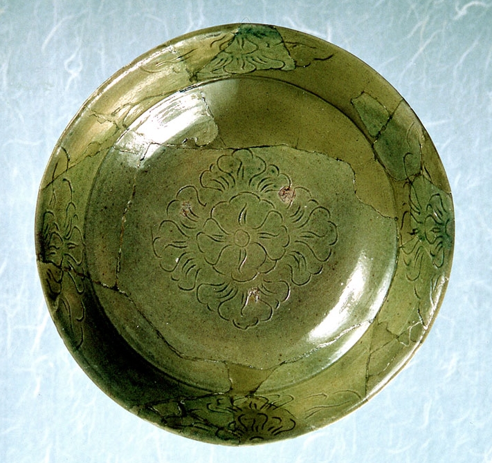 Green-glazed ceramic bowl with incised floral patterns