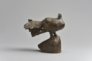 柳原義達が1986年に制作したブロンズ彫刻《道標・鳩》を撮影した写真。翼をたたんだクジャクバトが表されている。この写真では、鳩の頭が右側、尾が左側に捉えられ、鳩は頭を自分の尾の方に向けている。