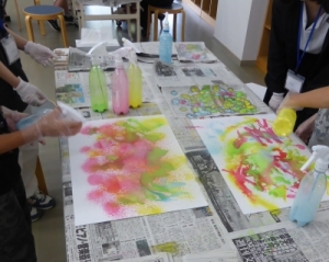 霧吹きのボトルに絵具を入れ、作品を作っている様子