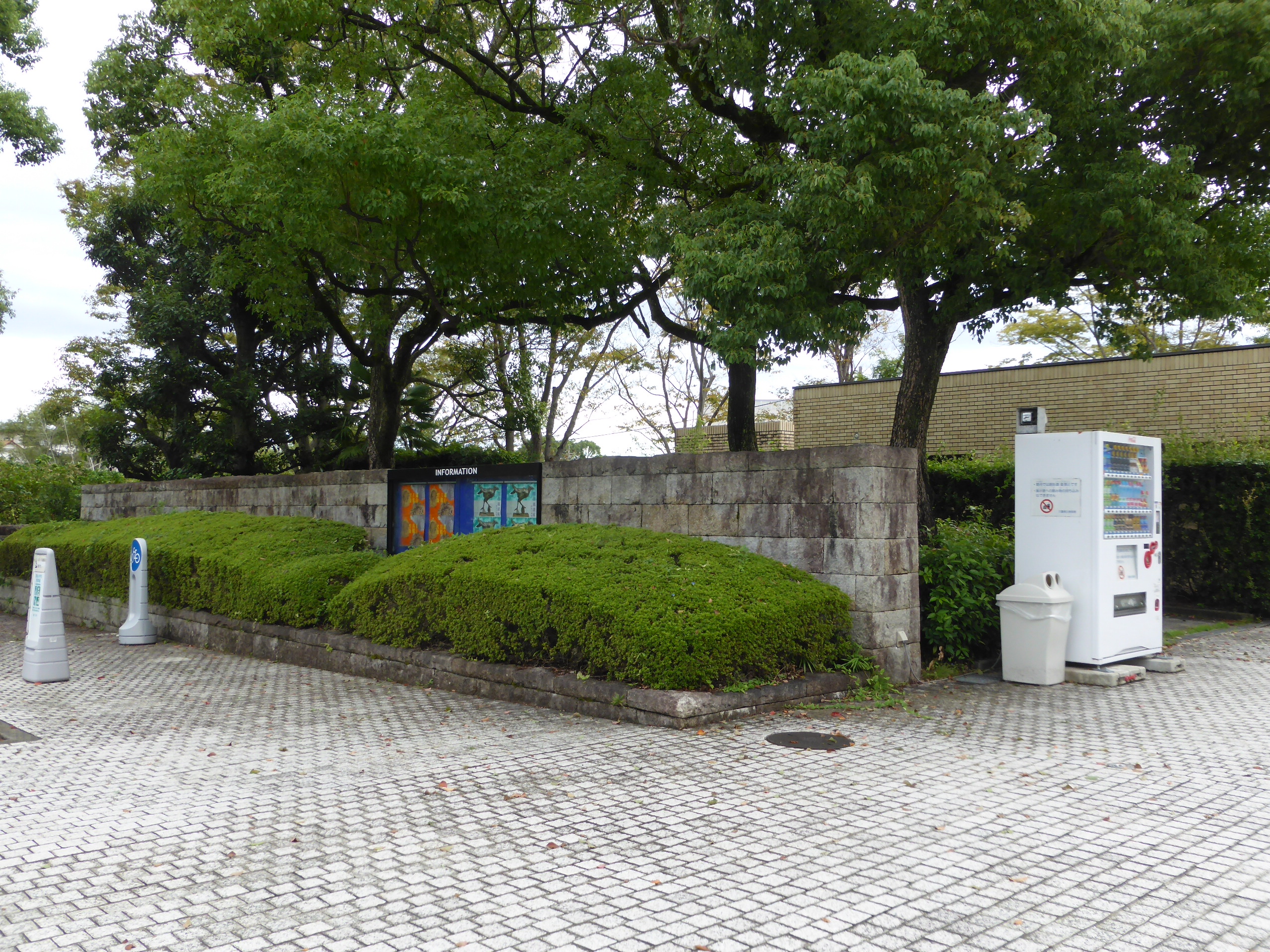 左手に駐輪場と思いやり駐車場、右手に白い自動販売機が見える