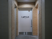 美術情報室前に2025年に増設した多機能トイレ入口。ドアにオストメイト対応、ユニバーサルシート設置のピクトグラム等を掲示。