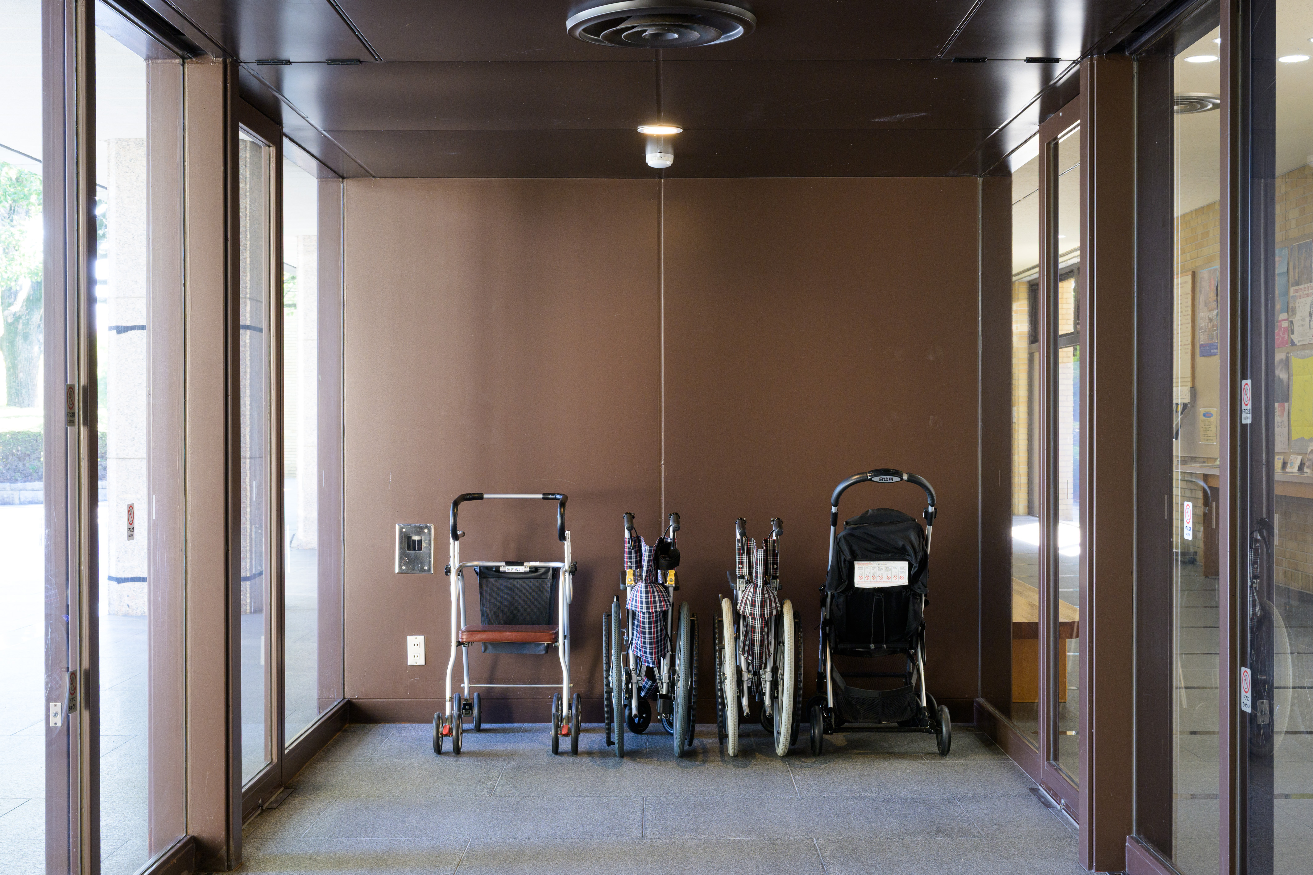 ベビーカー2台と車椅子2台が、美術館入口の風除室に置いてある