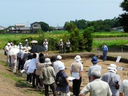 発掘調査現場見学の様子（皆さん熱心に説明を聞いていただいています）